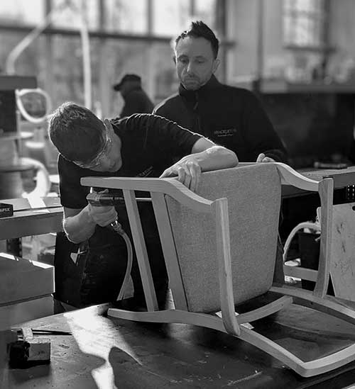 Apprentice upholstering a chair